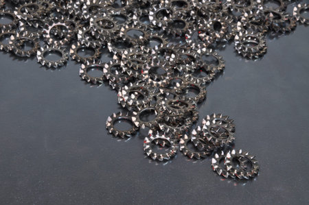 Shiny metal screw washers on a metal surfaceの写真素材
