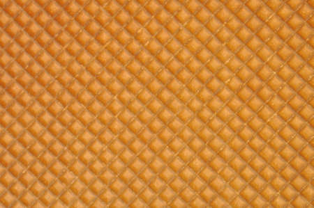 Golden waffle background with regular patternの写真素材