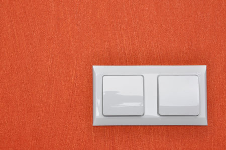 Double white light switch on red wallの写真素材