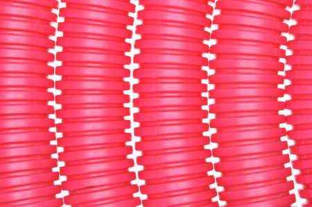 Red plastic corrugated pipe on white backgroundの写真素材