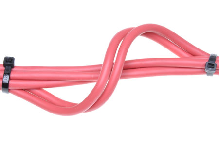 Red cables used in electrical wiring systems with black cable ties isolated on white background