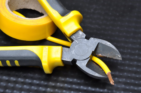 Pliers with electrical cable on metal background