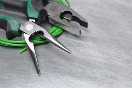 Green electrical tools and cables on metal surface with place for textの写真素材