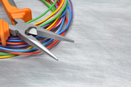 Tools for electrician and cables on gray metal surface