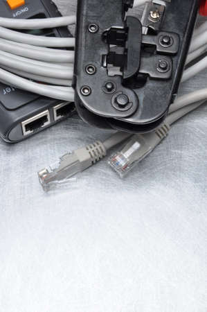 Network tester and crimping tool with RJ45 connector on metal background with place for textの写真素材