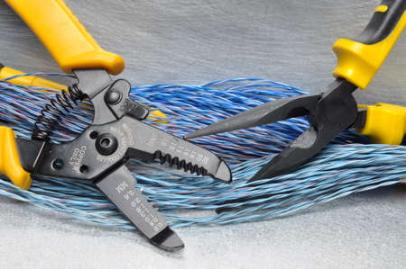 Crimping tool pliers and cables on gray background with place for textの写真素材