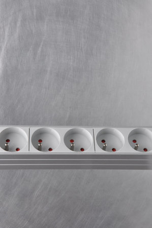 Power strip board or block extension on gray metal surface