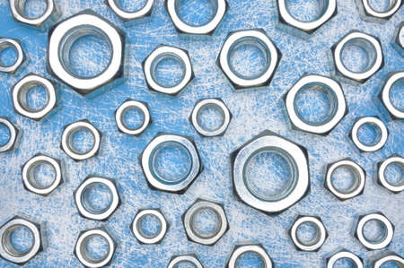 Steel nuts on blue metal backgroundの写真素材