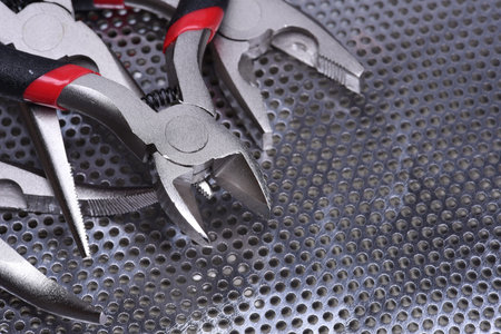 Electrical tools wire cutter, pliers on metal background