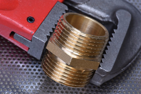 Closeup of brass threaded connector nipple with wrench