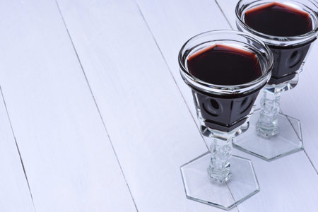 Glasses of red wine on a white wooden board