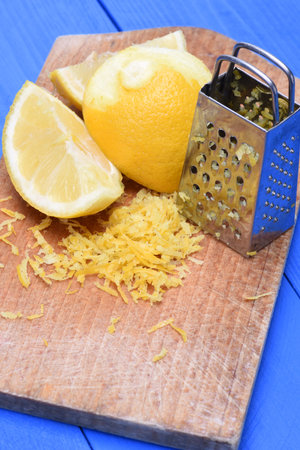 Fruit fruit lemon and lemon zest with grater on wooden board