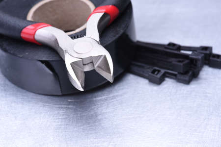 Pliers and electrical accessories on metal surfaceの写真素材