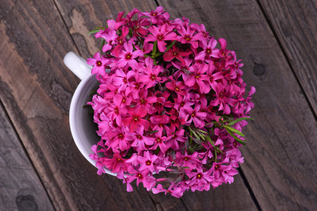 Bouquet of pink spring flowers on wooden board top viewの写真素材