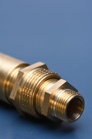 Brass fittings for water and gas on blue metal surfaceの写真素材