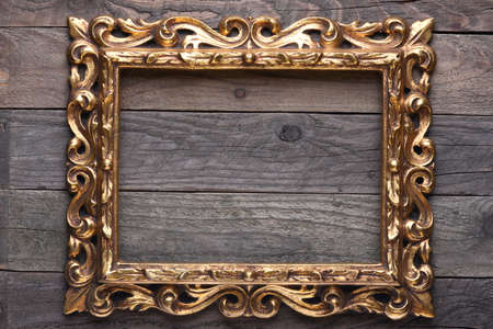 Antique Gold Wood Frame on Wooden Boardsの写真素材