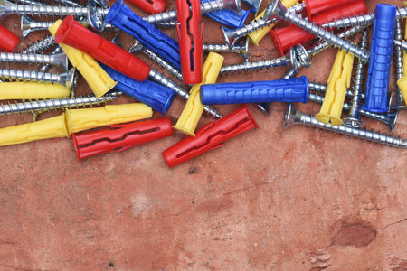 Plastic Dowels ans Screws on Red Brick Background