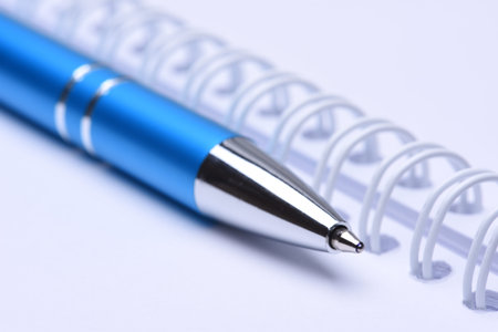 Notebook with blue pen closeup