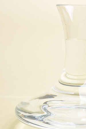 Glass carafe with water on beige background