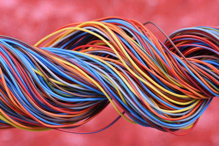 Multicolored electrical cable on red backgroundの写真素材