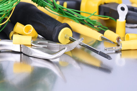 Set of electrical tools on metal surface with reflection
