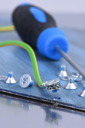 Tool, screw and cable on metallic background close-up