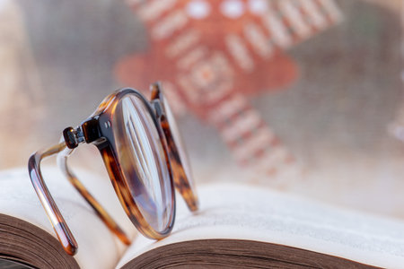 Soft focus reading glasses on open bookの写真素材