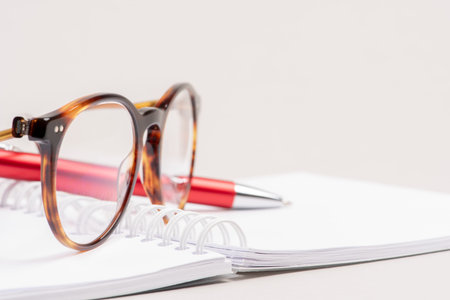 Open blank notebook pen and glasses on the tableの写真素材
