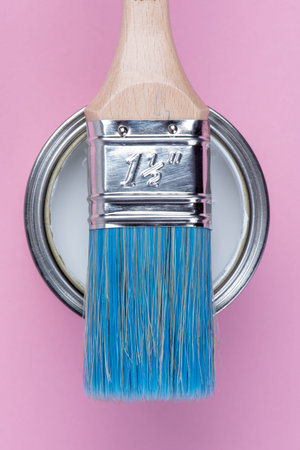 Can tin of white paint and paintbrush on pastel pink background top viewの写真素材