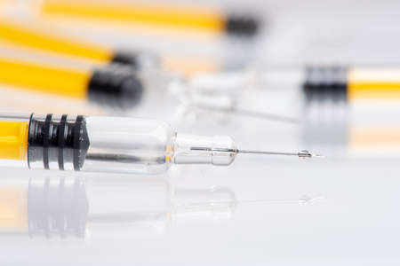 Syringe close-up with focus on needle with dropの写真素材
