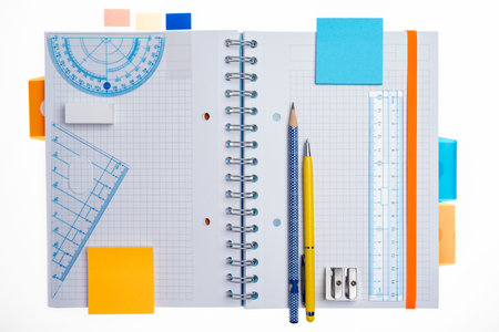 Notebook with office supplies accessories top view isolated on white background