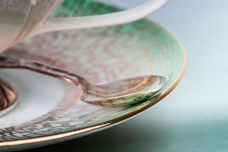 Macro porcelain cup of tea with silver spoonfulの写真素材