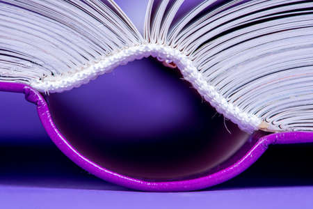 Open book hardcover close-up on violet backgroundの写真素材