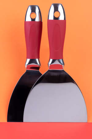 Professional putty knife on color wallpaperの写真素材