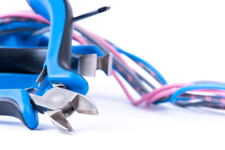 Colorful wiring and tool pliers used in electrical installation, isolated on white background