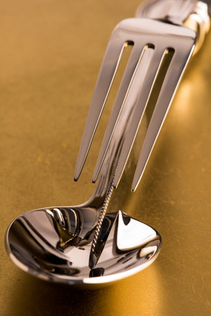 Macro of fork knife and spoon on metallic background