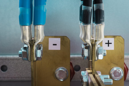 Joint of electric cable with copper busbar by bolts and nuts in electrical power supply switchboard