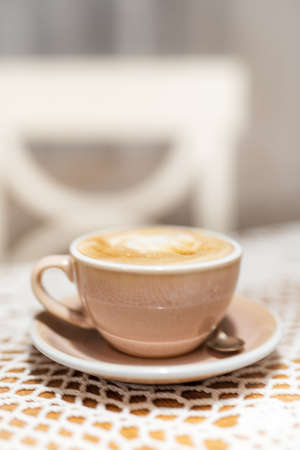 Cup of cappuccino on table with soft blurred backgroundの写真素材