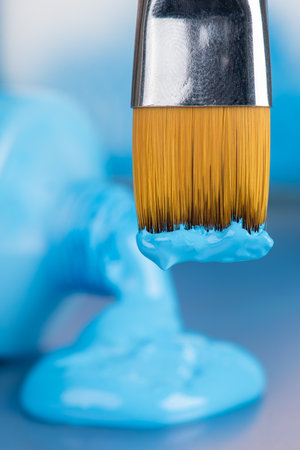 Tube of opened blue paint and paintbrush toolの写真素材