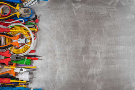 Set of different hand tools, component and accessories to use in electrical installation on metal background top viewの写真素材