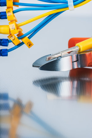 Tool pliers and cable on metal plate, electrical installations