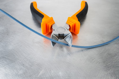 Electrical hand tool cut cable on grunge metal background