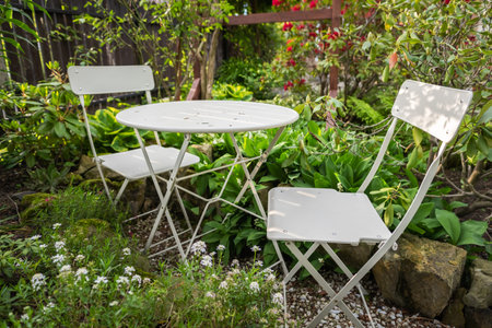 Empty bistro coffee table with chairs in green garden