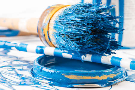 Closeup old used paint brush used in home improvement lying on dirty painted tableの写真素材