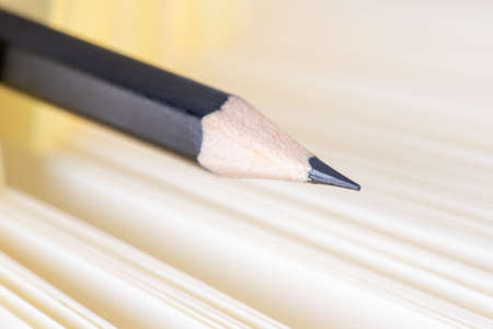 Pencil closeup with selective focus and paper notebook in blurred backgroundの写真素材