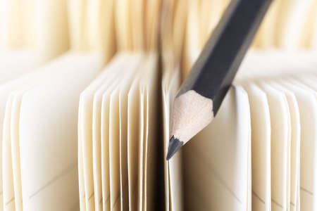 Pencil closeup with selective focus and paper notebook in blurred backgroundの写真素材