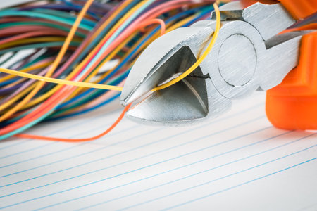Electrician tools and colorful wires on a white sheet of paper.の写真素材
