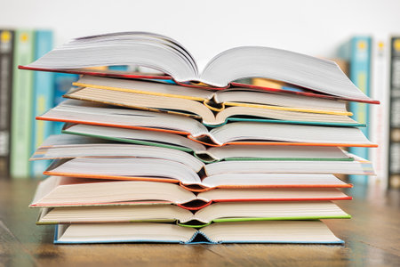 Stack of books on wooden table in library. Education and learning concept.の写真素材