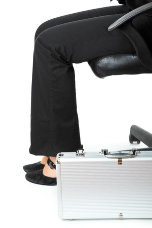 Suitcase at legs  of business woman sitting on chair  isolated on white
の写真素材