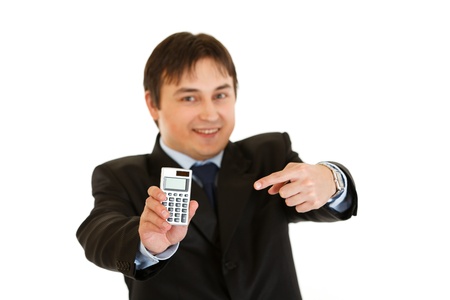 Smiling modern businessman pointing finger on calculator isolated on whiteの写真素材